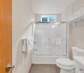 Step into your private bathroom, where fresh towels wait by a gleaming tub-shower combo. Natural light from above bathes the bright white space, making every morning feel refreshing.
