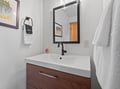 Refresh in your stylish bathroom featuring a modern vanity, black fixtures, and fluffy towels ready for your arrival.